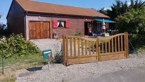 A wooden building with a sloped roof, a wooden gate, and a mailbox. - Chalet Les Adrets de Sancy-au Coeur de L'auvergne (Saint-Diéry)
