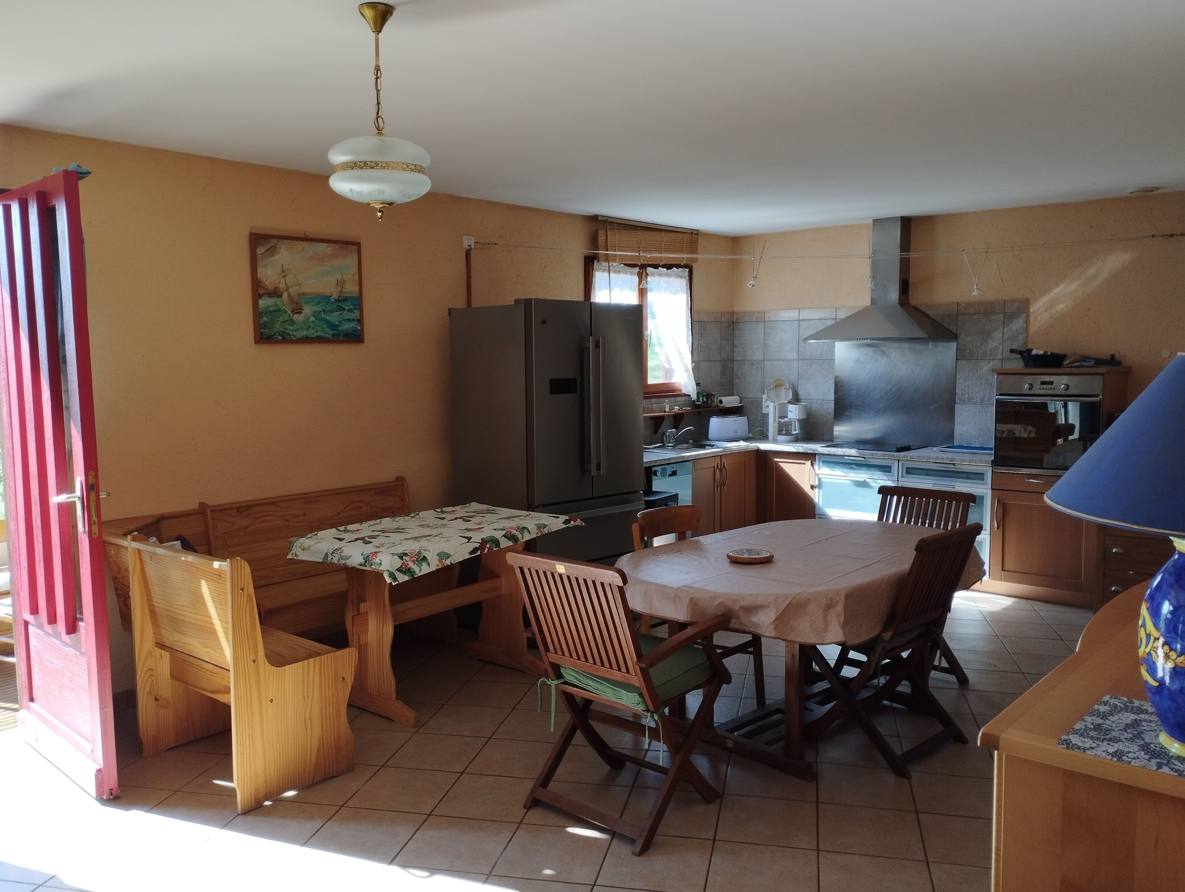 A compact kitchen with a dining area, a refrigerator, a stove, and a sink.