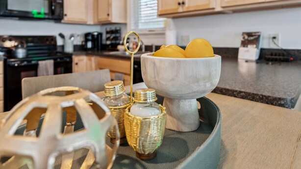 A kitchen counter with a bowl of lemons, a decorative metal object, and two wicker containers. - Newly Renovated Tremont Treasure I Cozy + Modern (Cleveland)