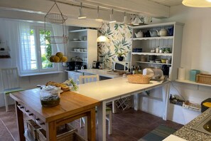 A kitchen with a wooden table, hanging light fixture, and white cabinetry. - Holiday home in the countryside, with pool, garden (Rozewko)