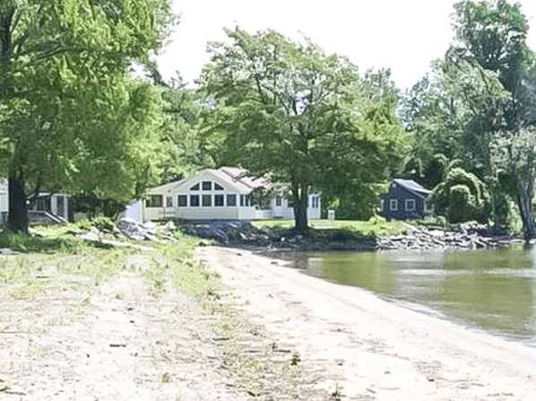 A lakeside property with a dirt path leading to a house. - Bright 3 Bedroom Lake Cottage with dock! (North Hero)