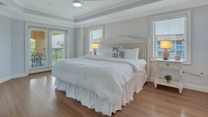 Ein Schlafzimmer mit einem großen Bett, einem Deckenventilator und einem Fenster mit Jalousien.