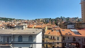 Una zona urbana densamente poblada con edificios de techos de teja rojiza, algunos con antenas parabólicas y unidades de aire acondicionado visibles.