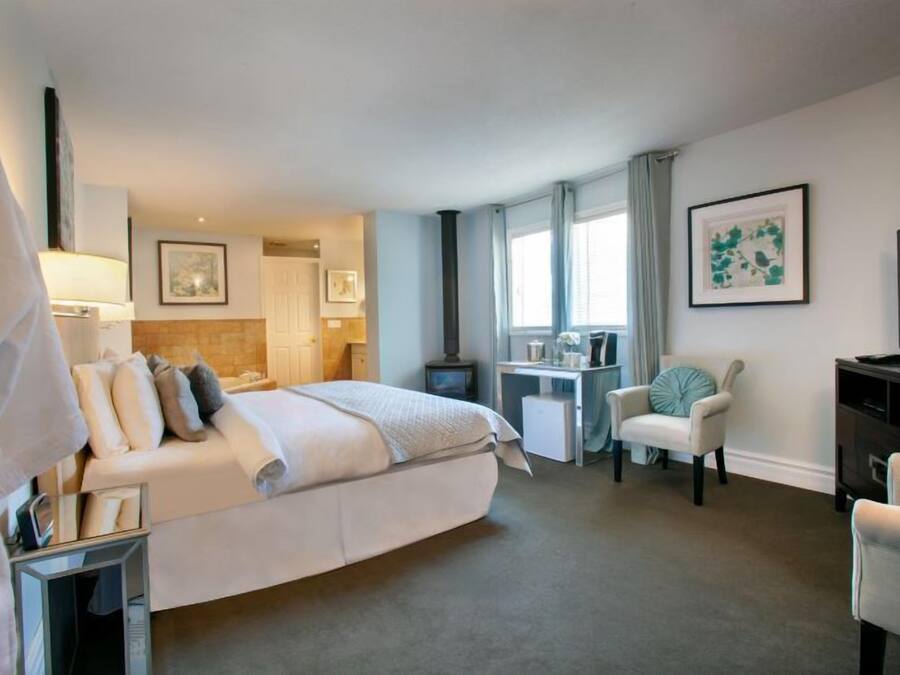 A hotel room with a bed, a desk, a chair, and a TV.