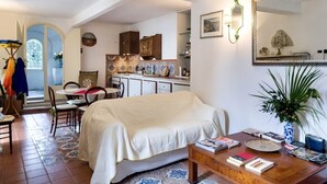 A cozy bedroom with a bed, a dining table, and a kitchen in the background. - Incredible villa facing Portofino (Zoagli)