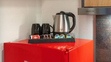 A red Hisense appliance with a coffee maker and tea pots on top.