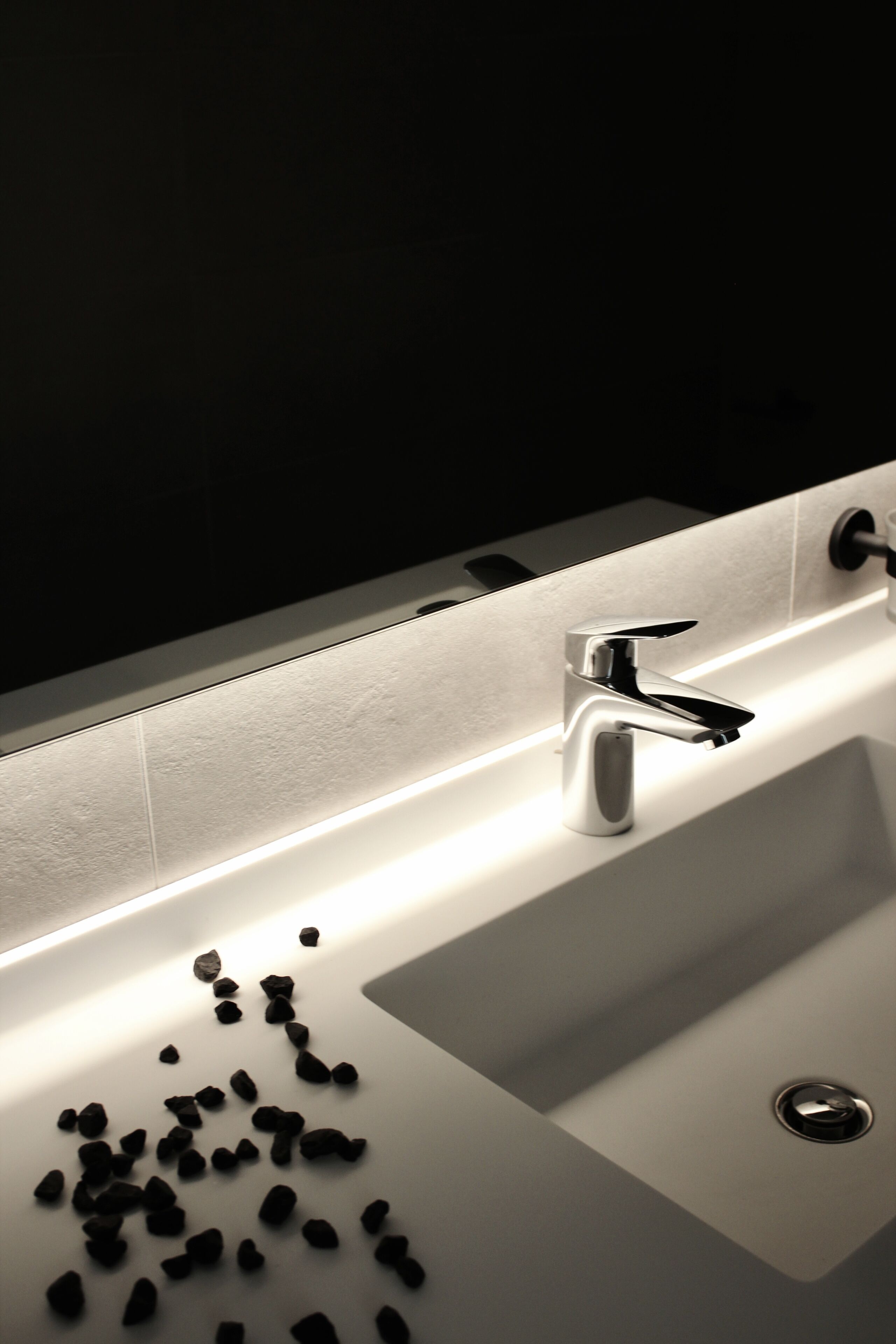A modern bathroom with a chrome faucet and a white sink.
