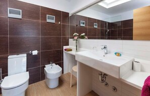 A modern bathroom with a toilet, bidet, sink, and mirror. - CAN PARRAS: Family home with a pool and barbecue, 3-minute walk from the beach (Sant Josep de sa Talaia)