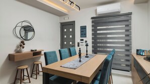 Un comedor moderno con una mesa de madera, sillas tapizadas en azul y un espejo decorativo en la pared.