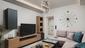 Una sala de estar moderna con un televisor de pantalla plana, mueble de madera para equipo audiovisual y un reloj de pared contemporáneo.