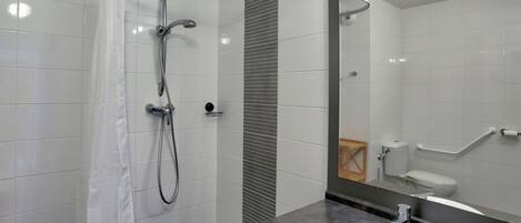 A modern bathroom with a shower, toilet, and sink.