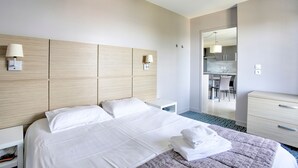 Une chambre d’hôtel avec un grand lit, des tables de chevet, un bureau et une chaise.