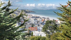 Une ville côtière avec des bâtiments qui bordent la plage, entourée d’arbres.