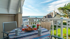 A balcony with a table set for breakfast, overlooking a scenic view.
