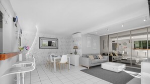 A modern living room with a dining area, a sofa, and a coffee table. - Prat d'Albis - Appt avec terrasse (Toulouse)