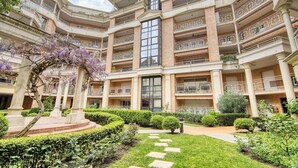 A multi-story building with balconies, a central courtyard, and a large window. - Prat d'Albis - Appt avec terrasse (Toulouse)