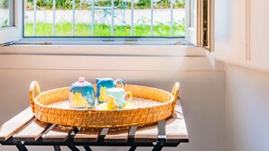 A window with a view of greenery and a blue chair outside. - Lisbon Prime Apartment (Lisbon)