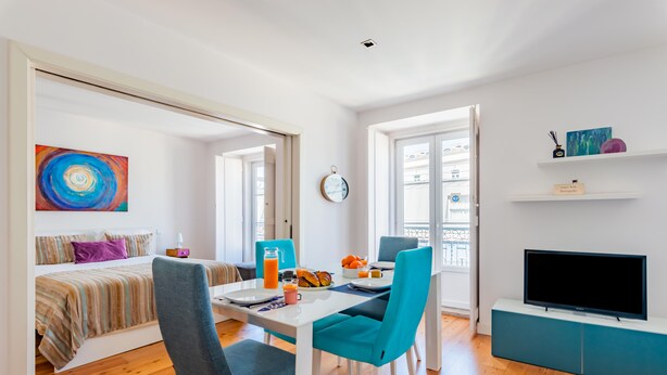 A modern living room with a dining area, a bed, a TV, and a painting on the wall. - Lisbon Prime Apartment (Lisbon)