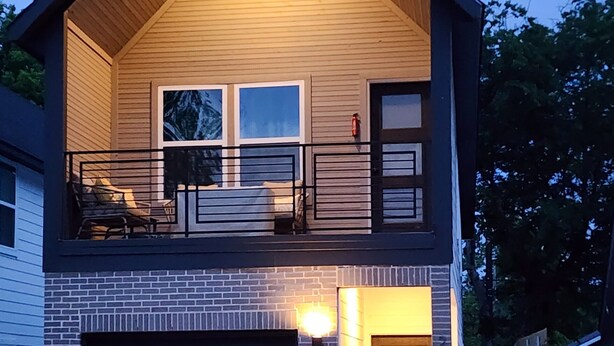 A two-story house with a garage, a balcony, and a brick facade. - Dallas Home (Dallas)