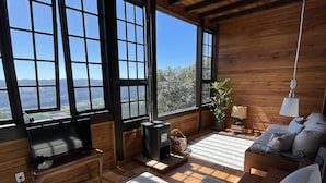 Una habitación acogedora con un ventanal grande, televisión, chimenea y sofá.