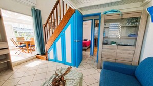 Ein Wohnzimmer mit Treppe, Essbereich und Küchenzeile.
