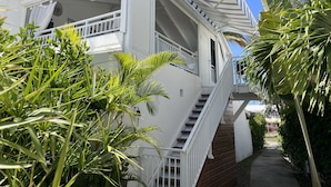 Ein weißes Gebäude mit Balkon und einer Treppe, die zu der oberen Etage führt.