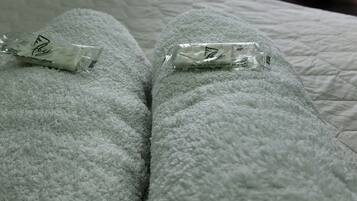 Una cama con una manta verde y dos paquetes pequeños encima.