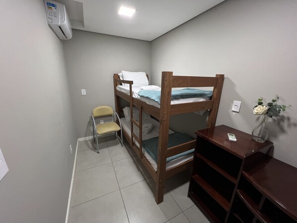 Habitación con literas, una silla y una mesita.