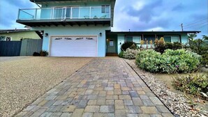 A two-story house with a garage, a paved driveway, and a well-maintained garden. - Carlsbad Beach Oasis+HotTub (Carlsbad)