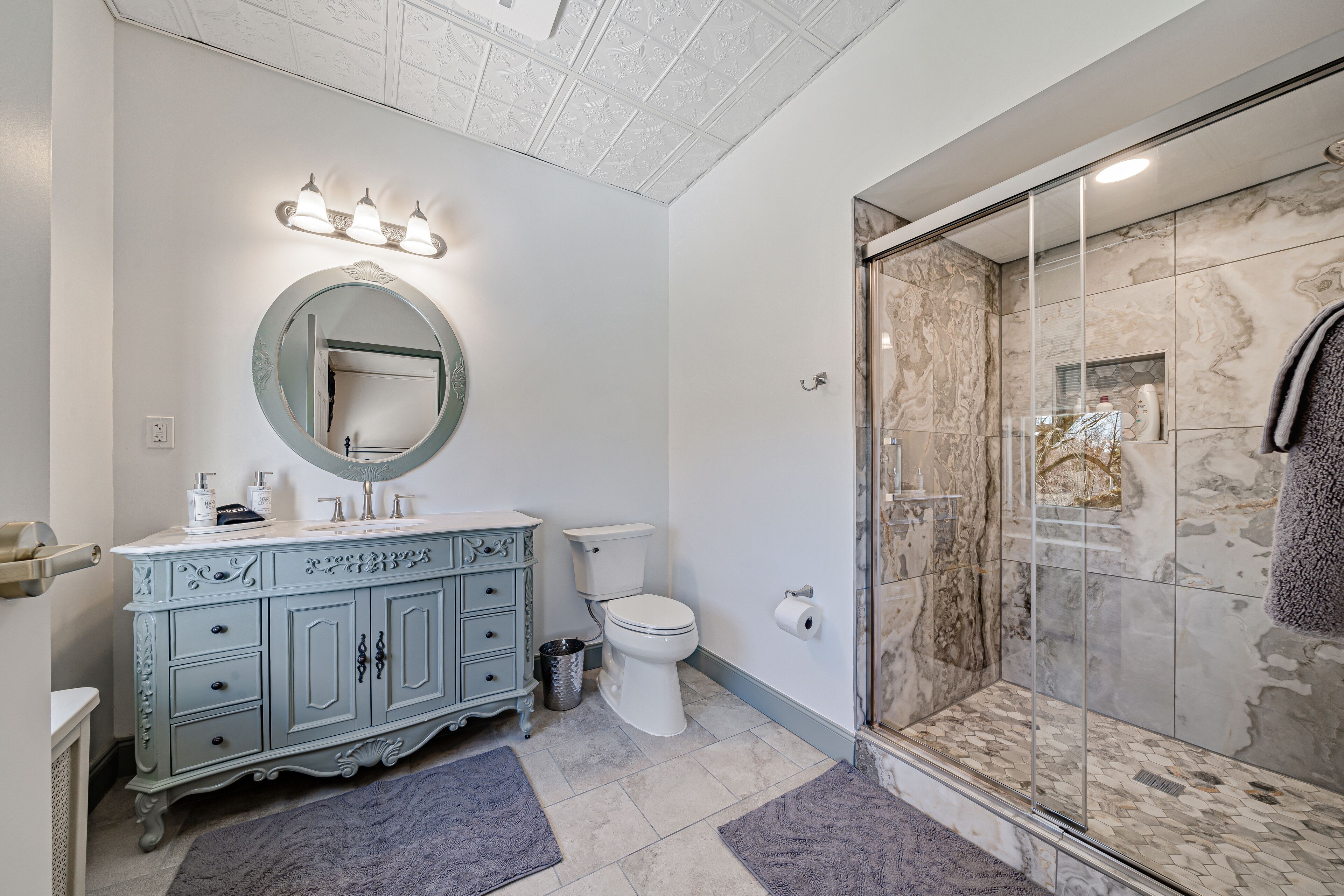 A bathroom with a vanity, toilet, and a glass-enclosed shower.
