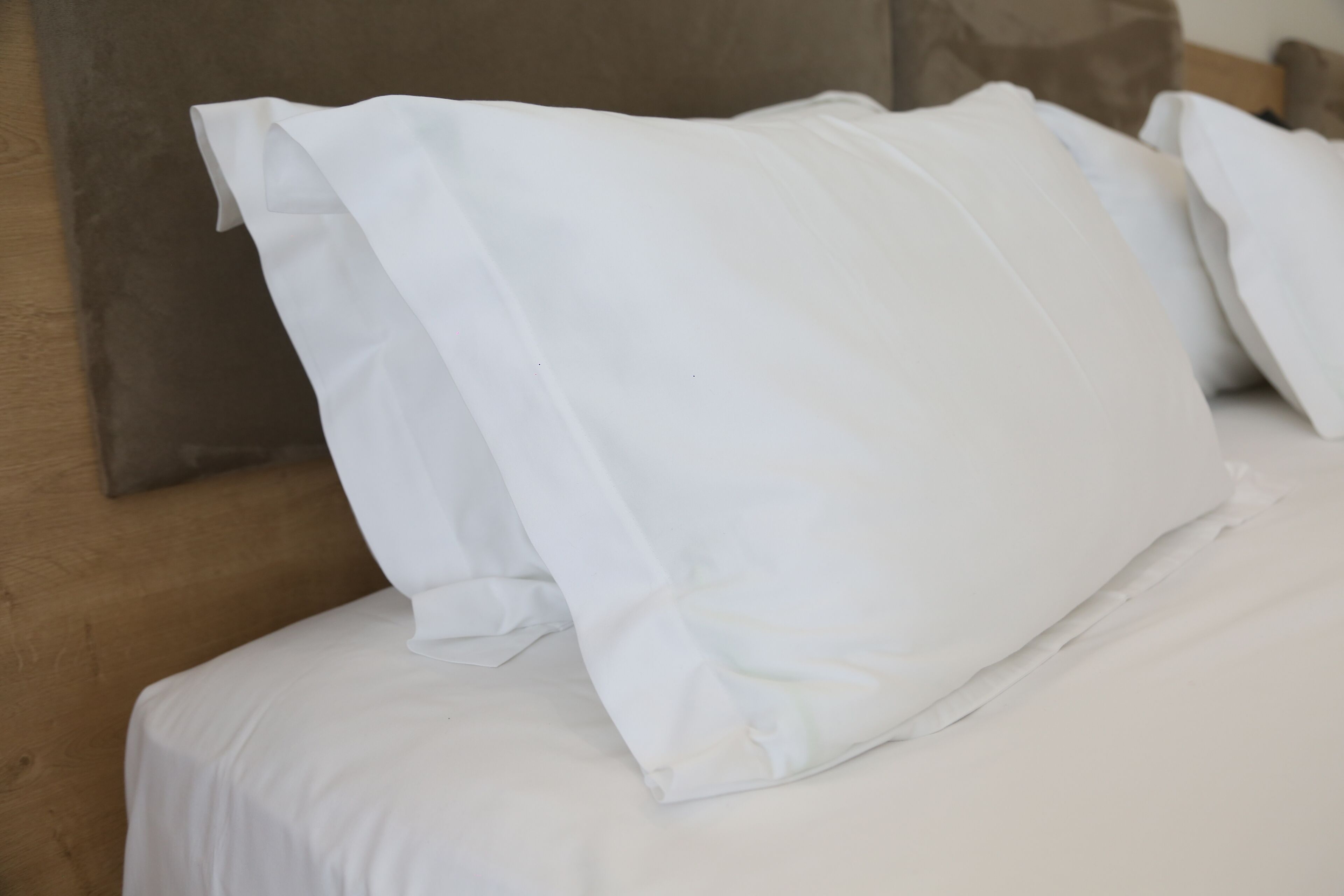 A bed with white bedding and pillows.