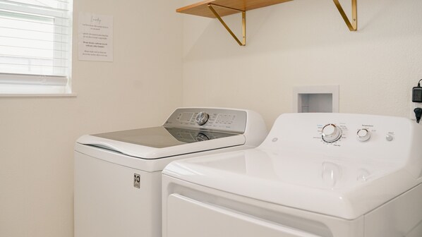 A laundry room with a front-loading washer and a top-loading dryer.