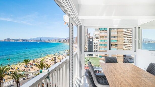 A balcony with a view of a beach and cityscape.