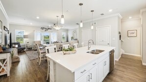 A spacious kitchen with a large island, white cabinetry, and pendant lighting. - NEW LISTING! Lost Key Golf & Beach Club~ Happy Ours -  NO HASSLE CHECK OUT (Pensacola)