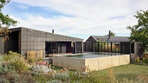 A modern house with a large outdoor swimming pool, surrounded by a variety of plants and a wooden deck. - HILLPLAINS HOUSE - 100% OFF GRID LUXURY (Metcalfe)