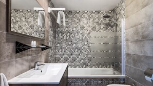 Een moderne badkamer met een ruime douche, een bad, een wastafel en een bidet.