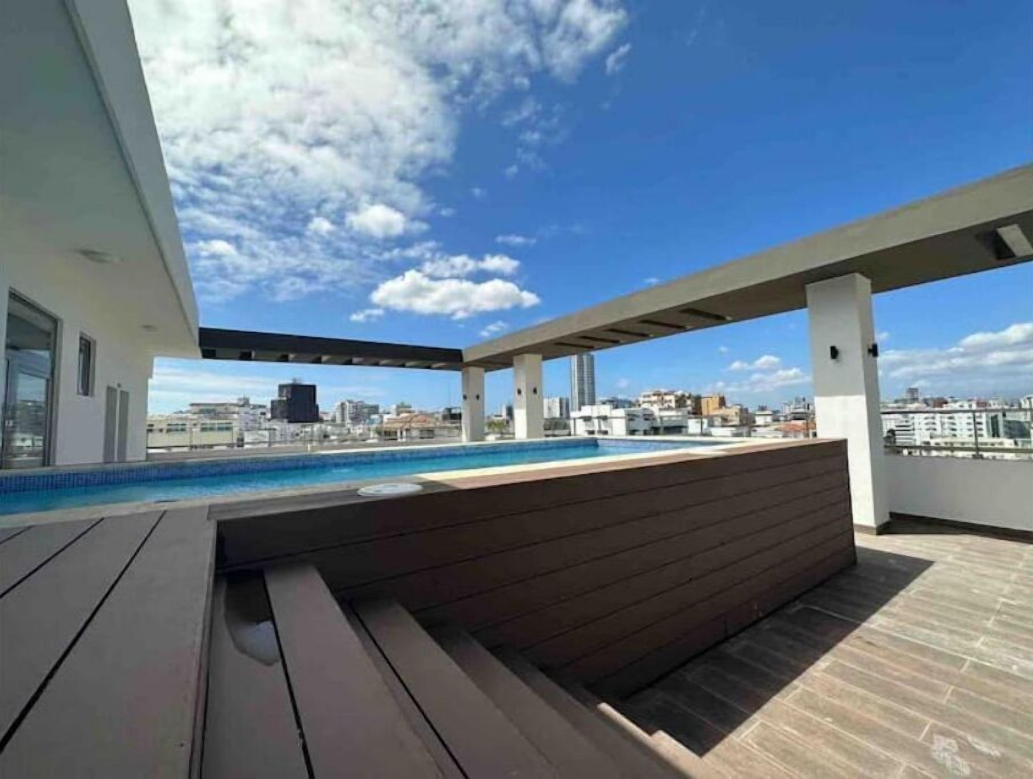 Une piscine située sur le toit, offrant une vue dégagée sur les gratte-ciel de la ville.
