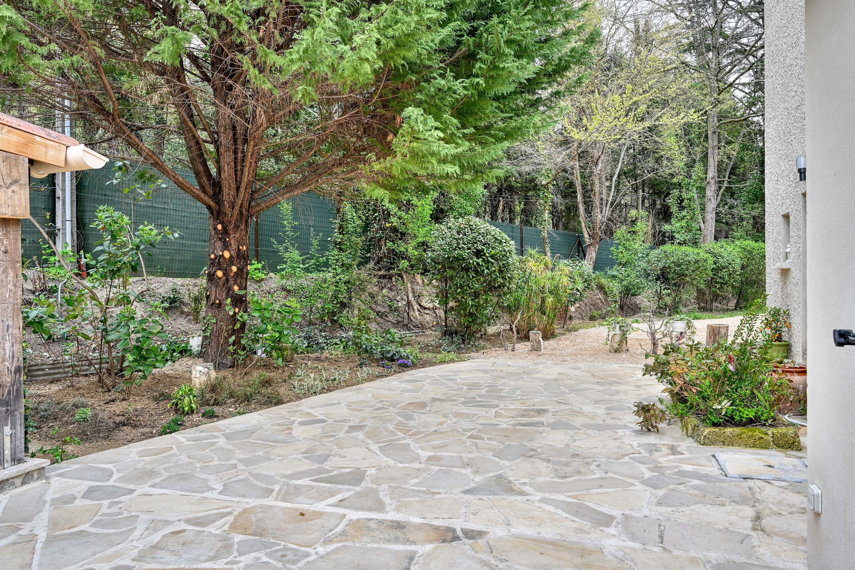 A stone pathway leading to a building with a wooden structure on the left.