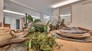 Een eettafel gedekt met servies, glazen en een decoratief middelpunt.