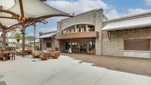 Mercado Sawgrass Grove con mesas al aire libre y fachada de ladrillo.