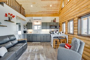 A modern log cabin interior with a living area, kitchen, and dining space. - Secluded Grand Junction Getaway w/ Sweeping Views! (Grand Junction)