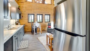 A modern kitchen with stainless steel appliances, wooden walls, and large windows. - Secluded Grand Junction Getaway w/ Sweeping Views! (Grand Junction)