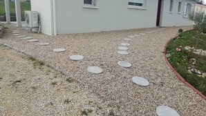 A building with a gravel pathway and stepping stones leading to the entrance. - Cosy home (Bassillac et Auberoche)