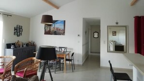 A spacious living area with a dining table, chairs, a lamp, and a painting on the wall. - Cosy home (Bassillac et Auberoche)
