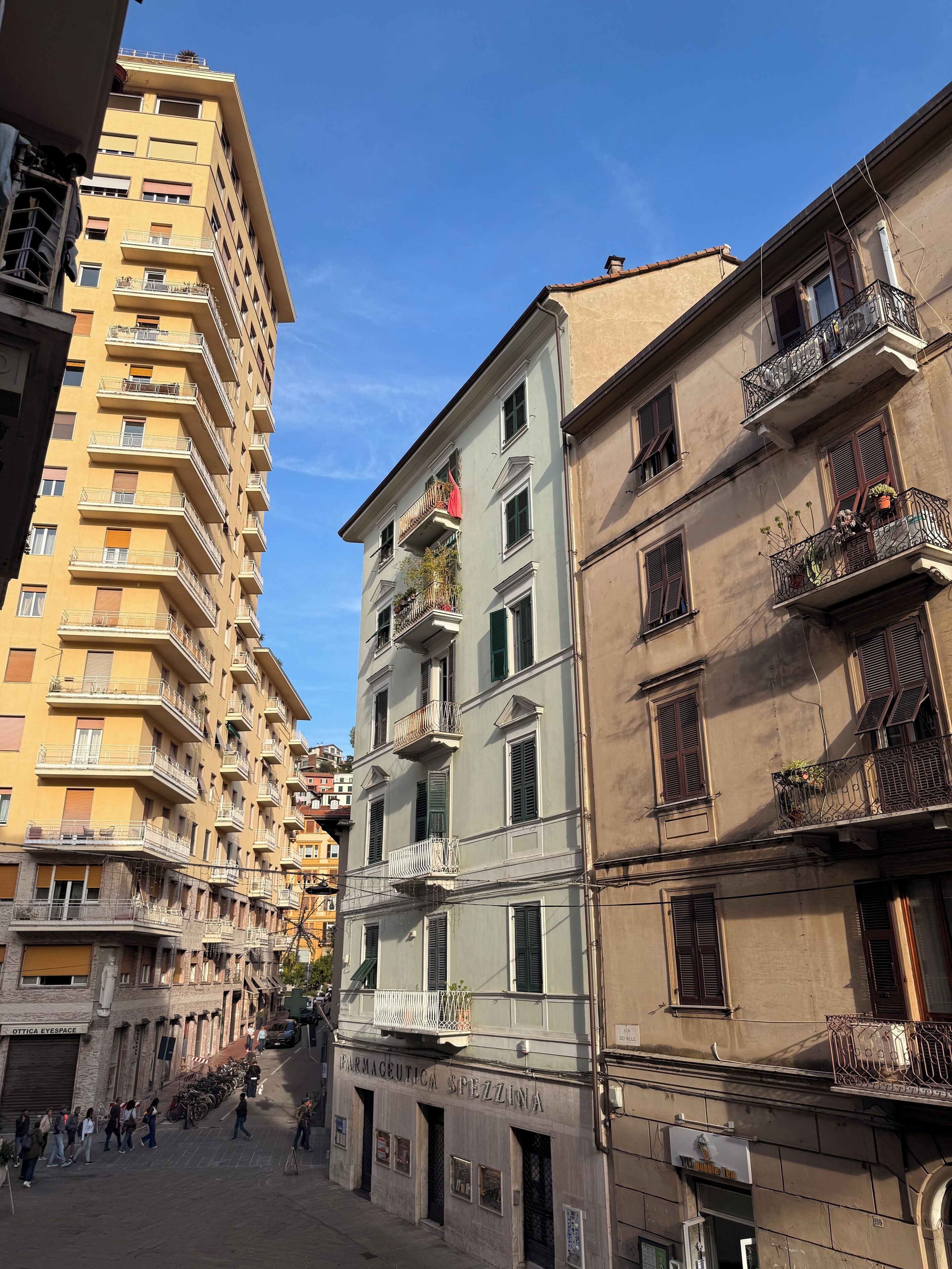 Un edificio a più piani con balconi, una farmacia e un negozio ben visibile.