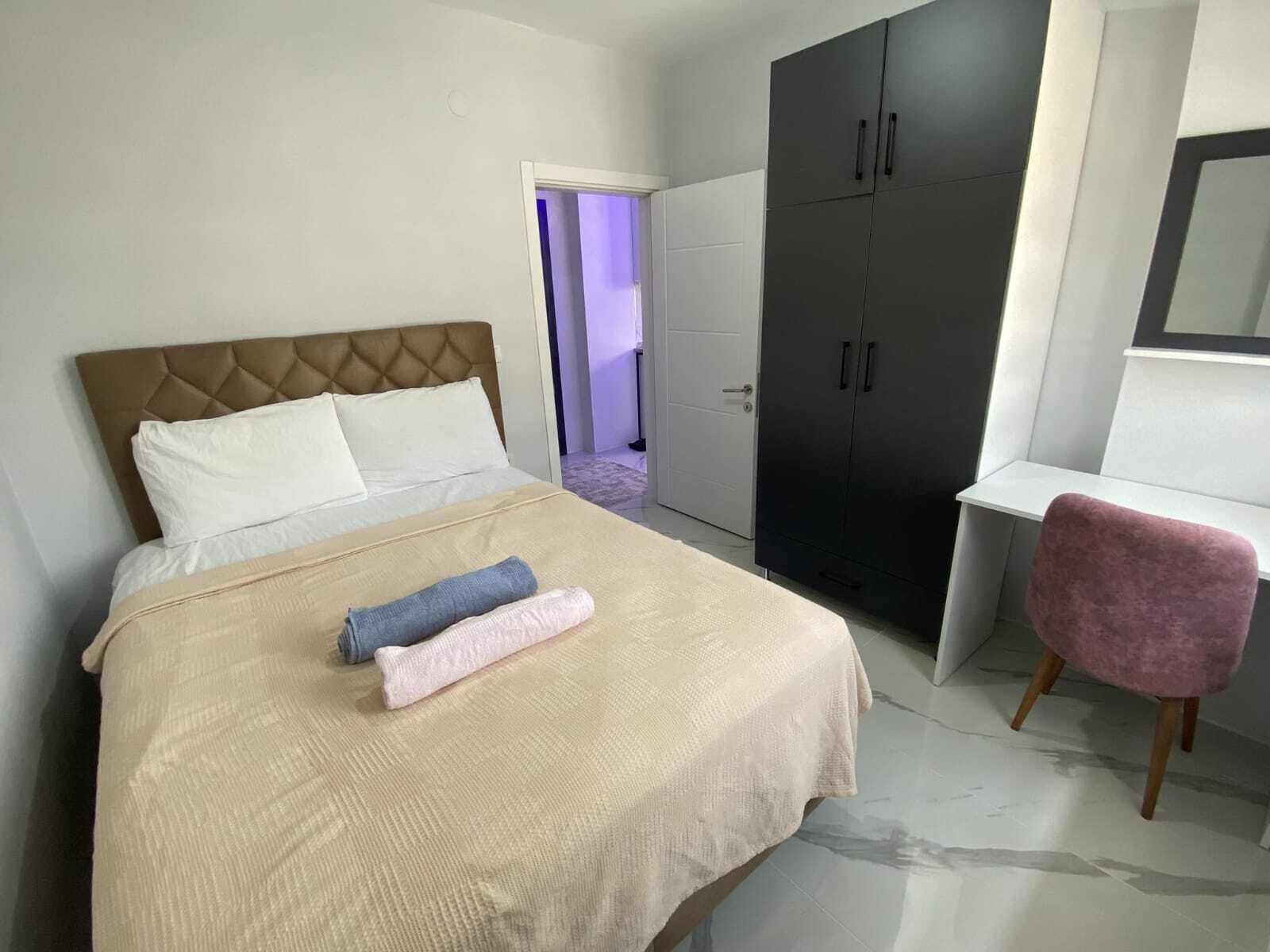 A bedroom with a bed, a wardrobe, and a desk.