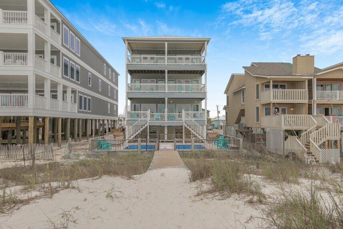 A beachfront building with multiple balconies and a central staircase.