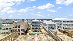 A beachfront hotel with multiple buildings, a pool, and a boardwalk.