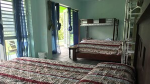 A room with two beds, a window with curtains, a door leading outside, and a ladder against the wall. - Perfect for large groups - House & Triplex w/private river access (Naguabo)