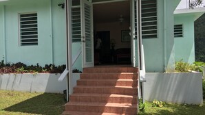 A two-story building with a staircase leading to the entrance. - Perfect for large groups - House & Triplex w/private river access (Naguabo)